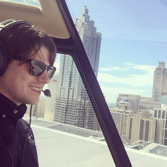 a person wearing sunglasses flying a helicopter