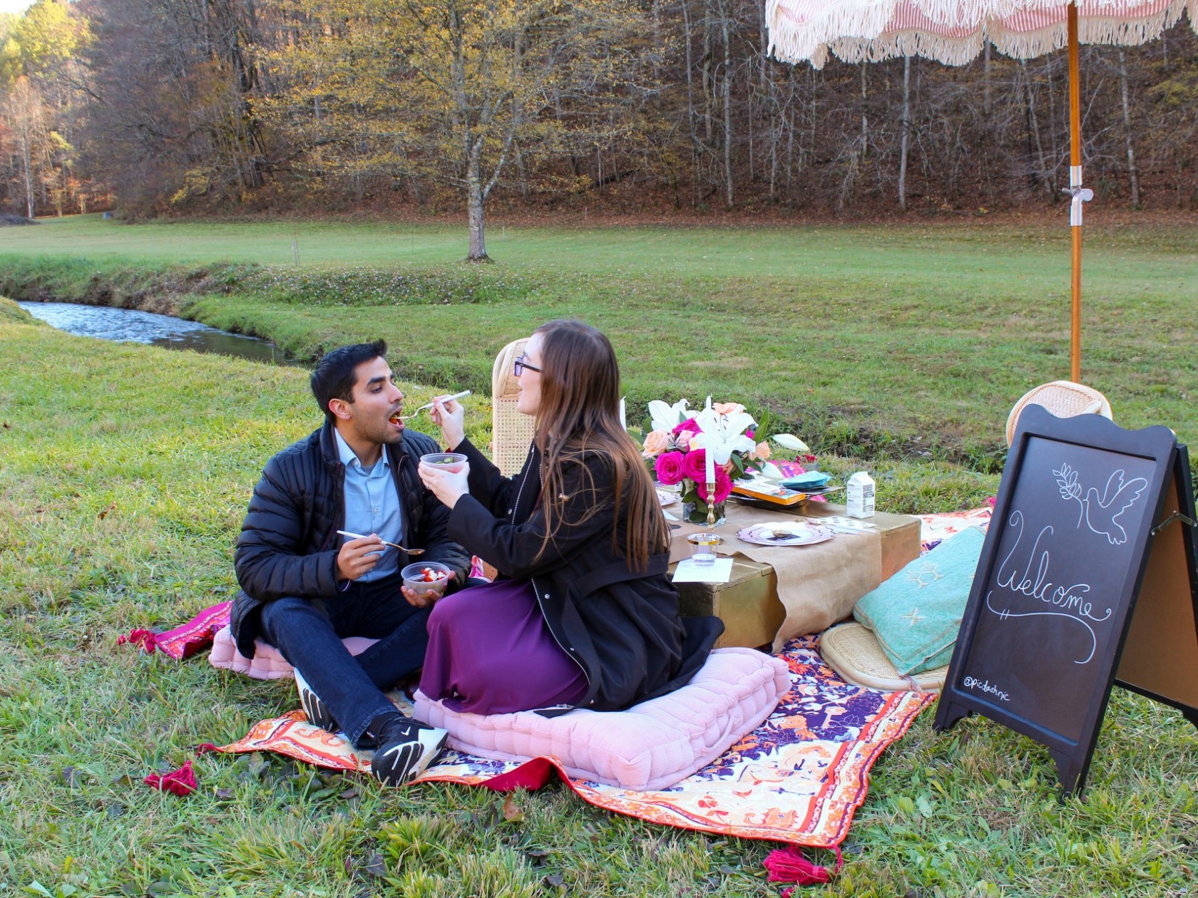a man and a woman sitting at a park