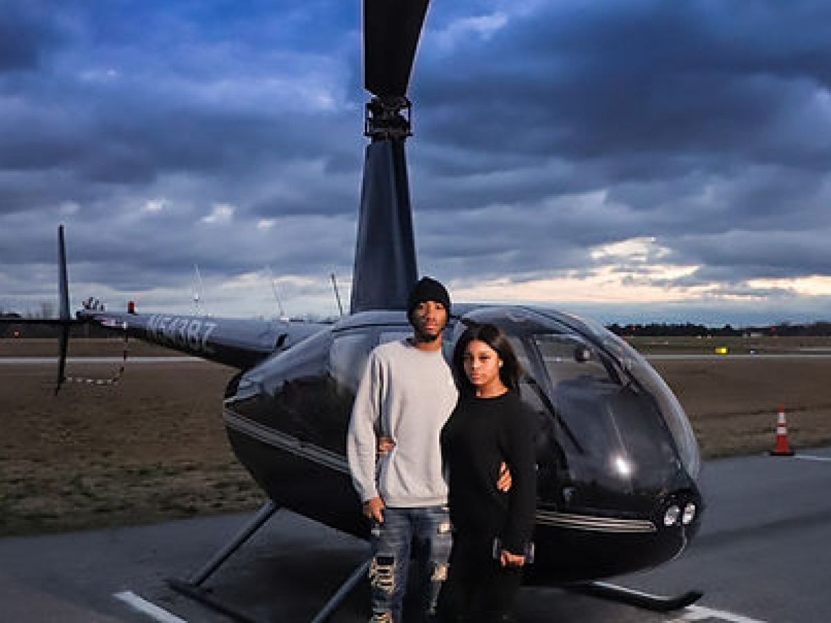 a couple standing in front of a plane