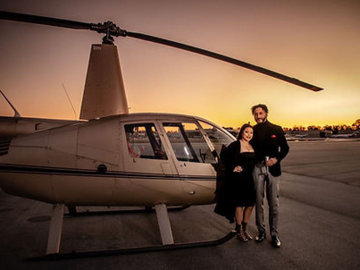 a man standing next to a person wearing a suit and tie standing in front of a building to a plane