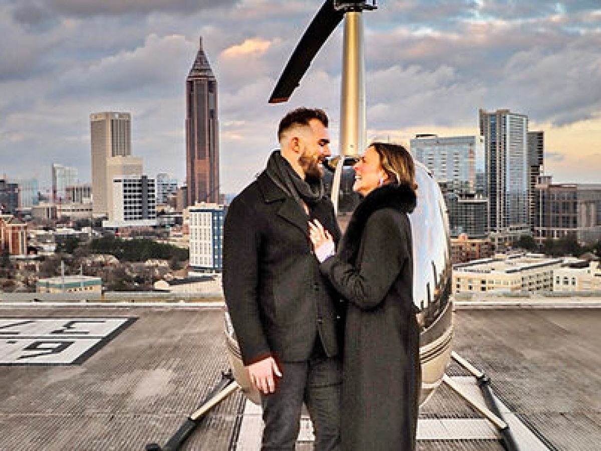 a person wearing a suit and tie standing in front of a building