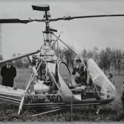 a group of people standing next to a helicopter